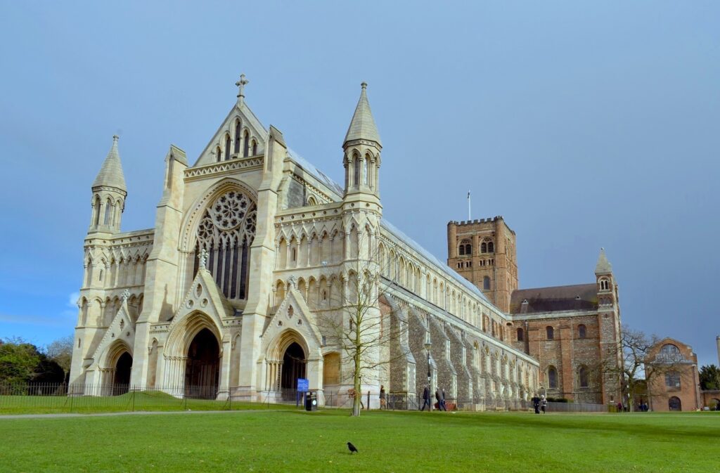 A large cathedral with spires and towers on a green field.